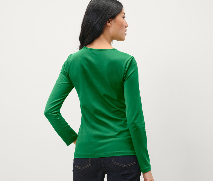 Frau von hinten trägt ein grünes Langarmshirt.