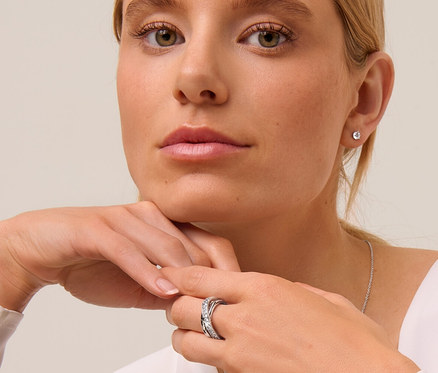 Blonde Frau mit 925 Silber Ohrstecker Solitär, 925 Silber Kette Solitär und Ring Loops mit Kristallen.
