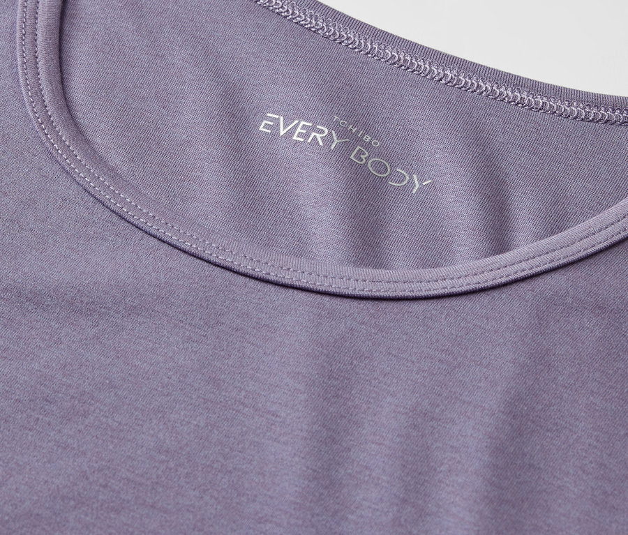 Detailaufnahme eines lila T-Shirts mit Rundhalsausschnitt und dem Aufdruck "EVERY BODY".