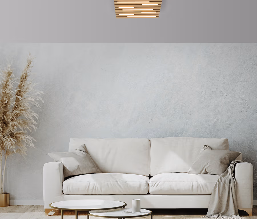 Wohnzimmer mit weißem Sofa, zwei Tischen und Deckenleuchte.