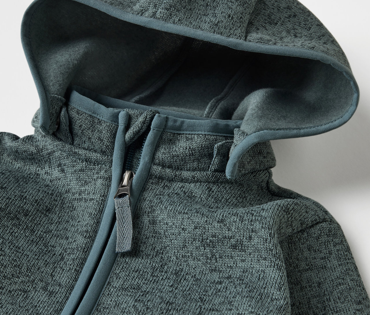 Detailansicht des Baby-Strickfleece-Overalls mit Reißverschluss und Kapuze.