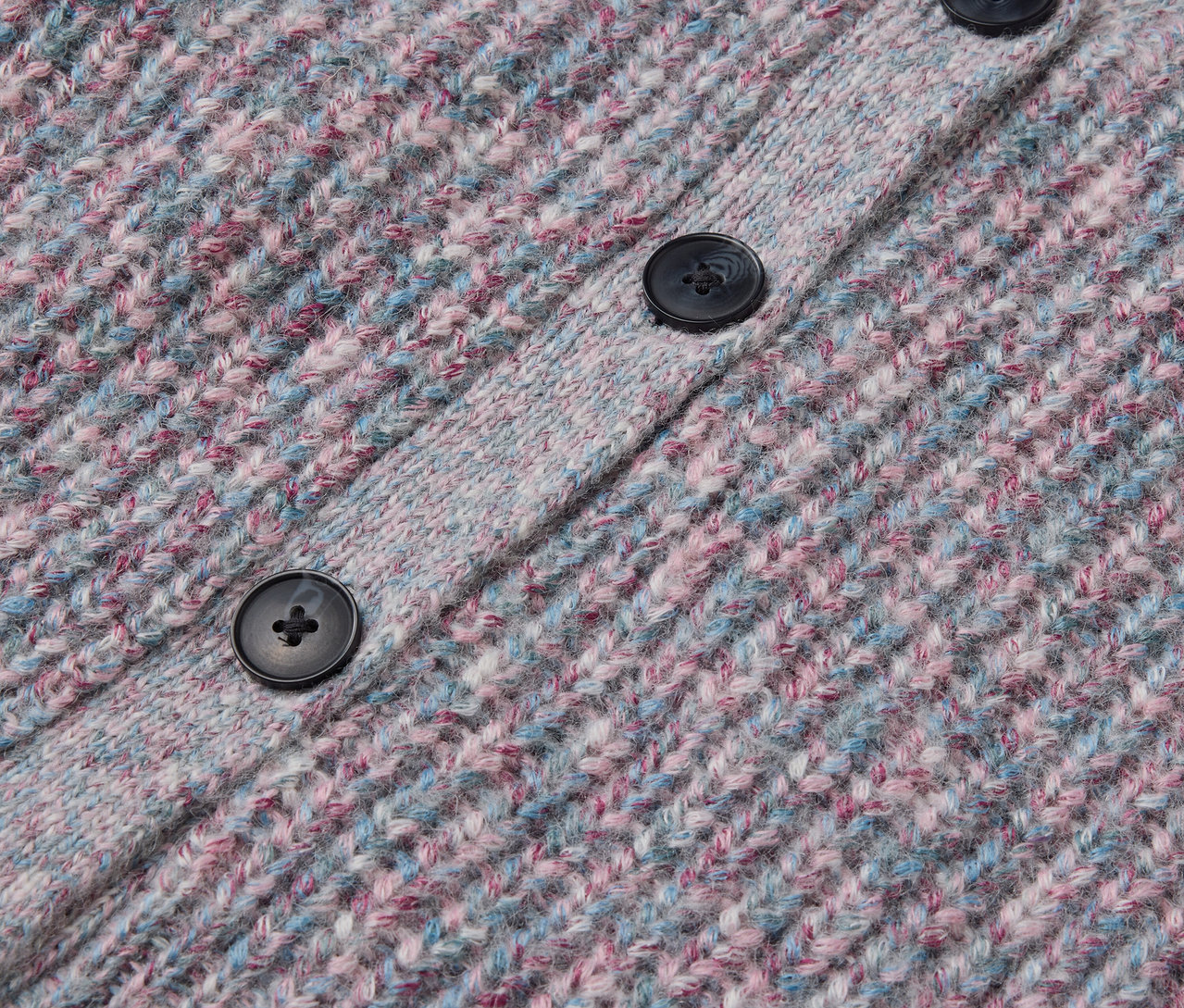 Detailaufnahme einer Kinder-Strickjacke mit RWS-zertifizierter Wolle, mit Knöpfen.