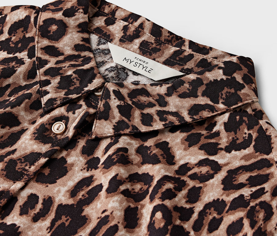 Detailansicht eines braun-schwarzen Hemdes mit Leopardenmuster, Kragen sichtbar.