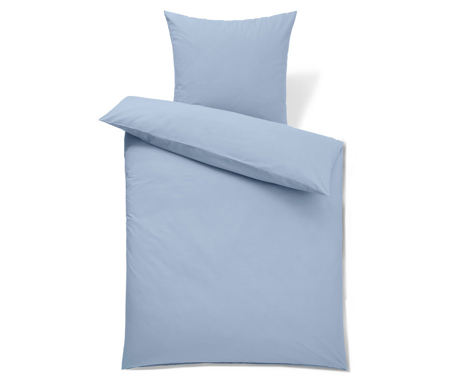 Hellblaue Bettwäsche mit Kissen und Bettdecke.