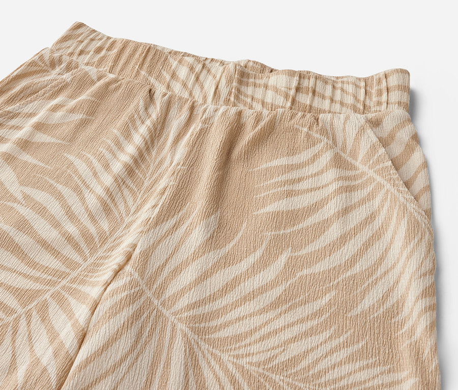 Detail einer strukturierten Palazzohose mit Alloverprint.