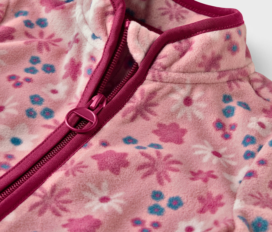 Detailaufnahme einer Kinder-Fleecejacke mit Blumenmuster und Reißverschluss.