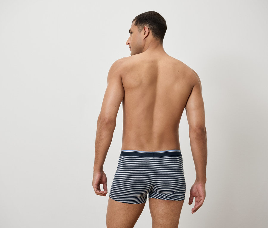 Mann von hinten trägt gestreifte Boxershorts.