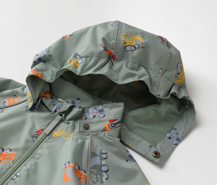 Nahaufnahme einer olivgrünen Kinderjacke mit Kapuze, bedruckt mit Bauwagen.
