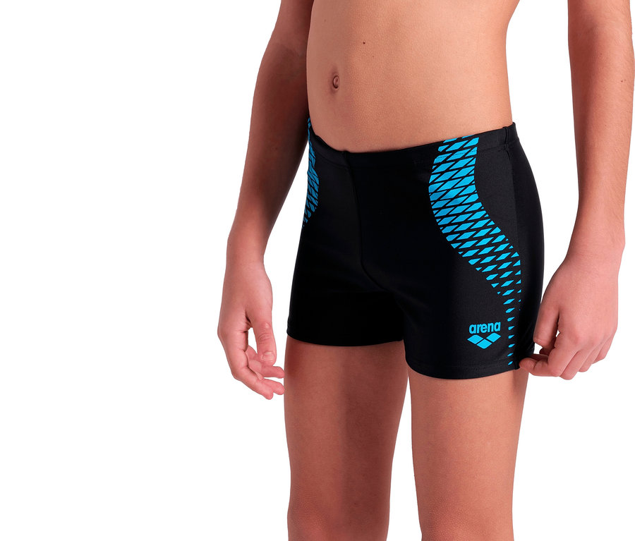 Nahaufnahme eines Jungen, der eine schwarze Arena-Badehose mit blauem Muster trägt.