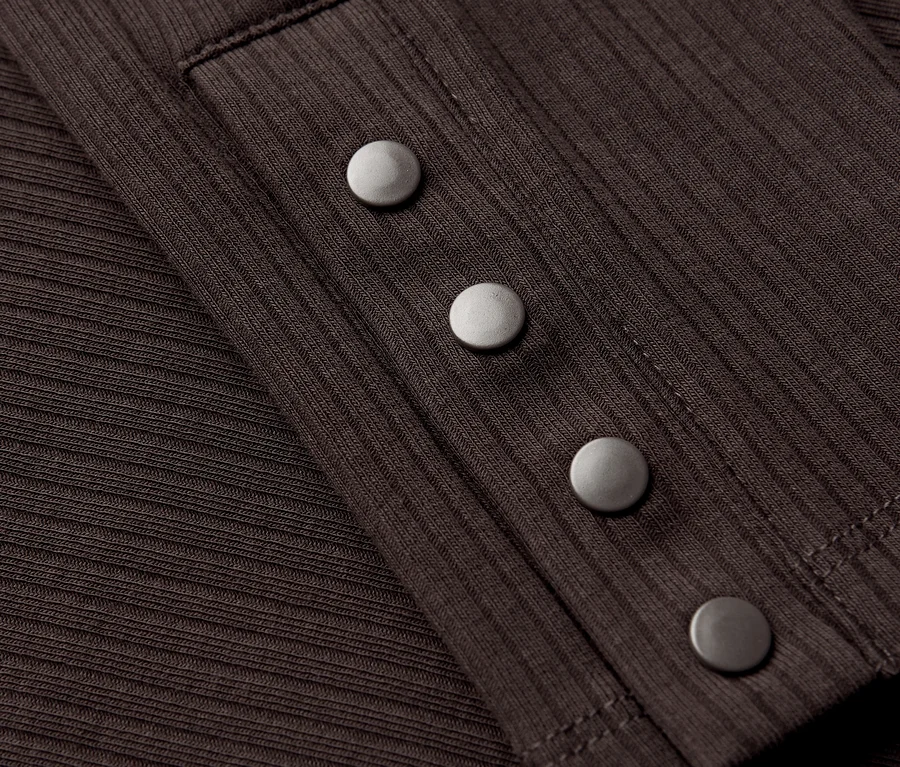 Detailansicht eines braunen Street One Rippshirts mit silbernen Knöpfen.