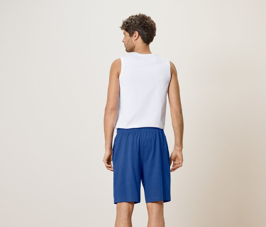 Rückansicht eines Mannes mit weißem Tanktop und blauen Shorts.