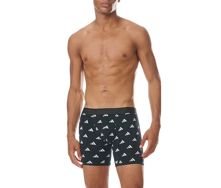 Ein oberkörperfreier Mann steht frontal da und trägt schwarze Boxershorts mit einem wiederholten weißen Adidas-Logo-Muster.