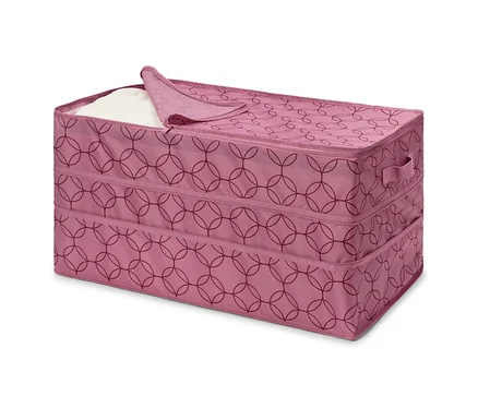 Rosa Stoffbox mit Reißverschluss und geometrischem Muster, teilweise mit weißem Stoff gefüllt.