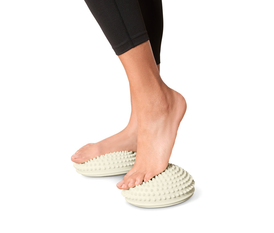Füße stehen auf 2 Balance-und-Massage-Pads.