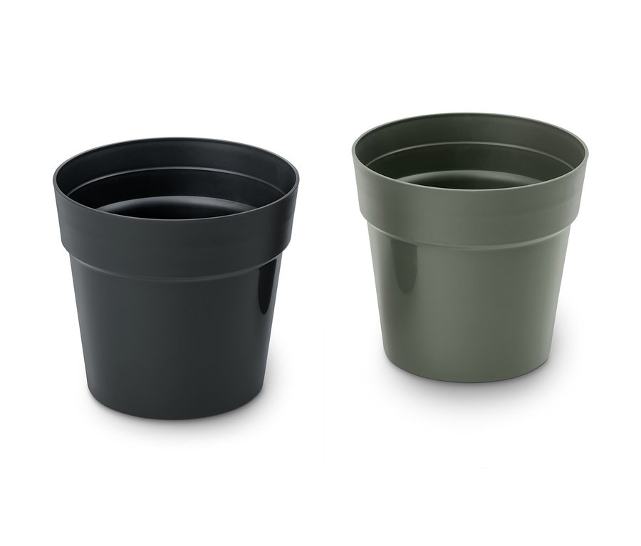 Zwei Kräuter-Übertöpfe, einer schwarz und einer grün.