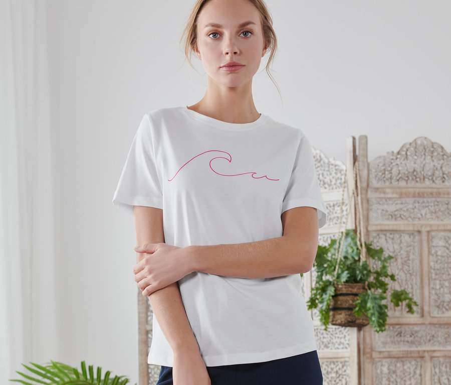 Frau trägt ein weißes T-Shirt mit Print.