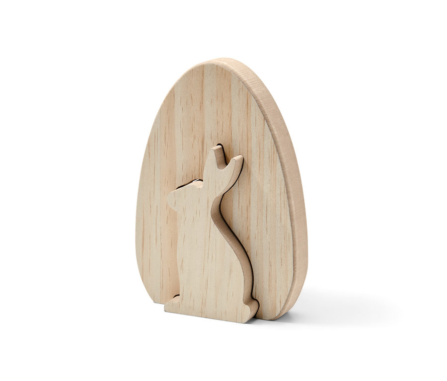 Ein Deko-Hase aus unlackiertem Holz in Form eines Eis, in dem ein Hase ausgeschnitten ist.