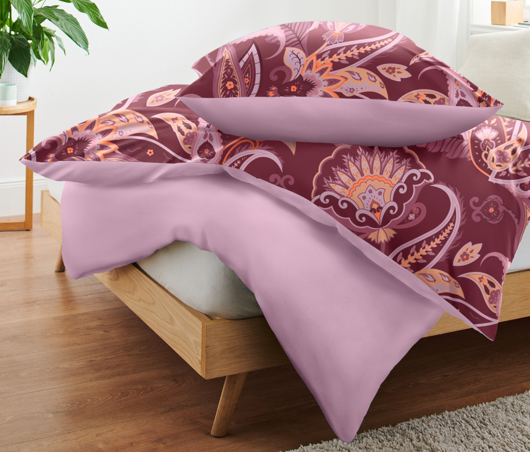 Auf einem Bett liegen gestapelt Microfaser-Bettwäsche in Normalgröße und eine in Übergröße.