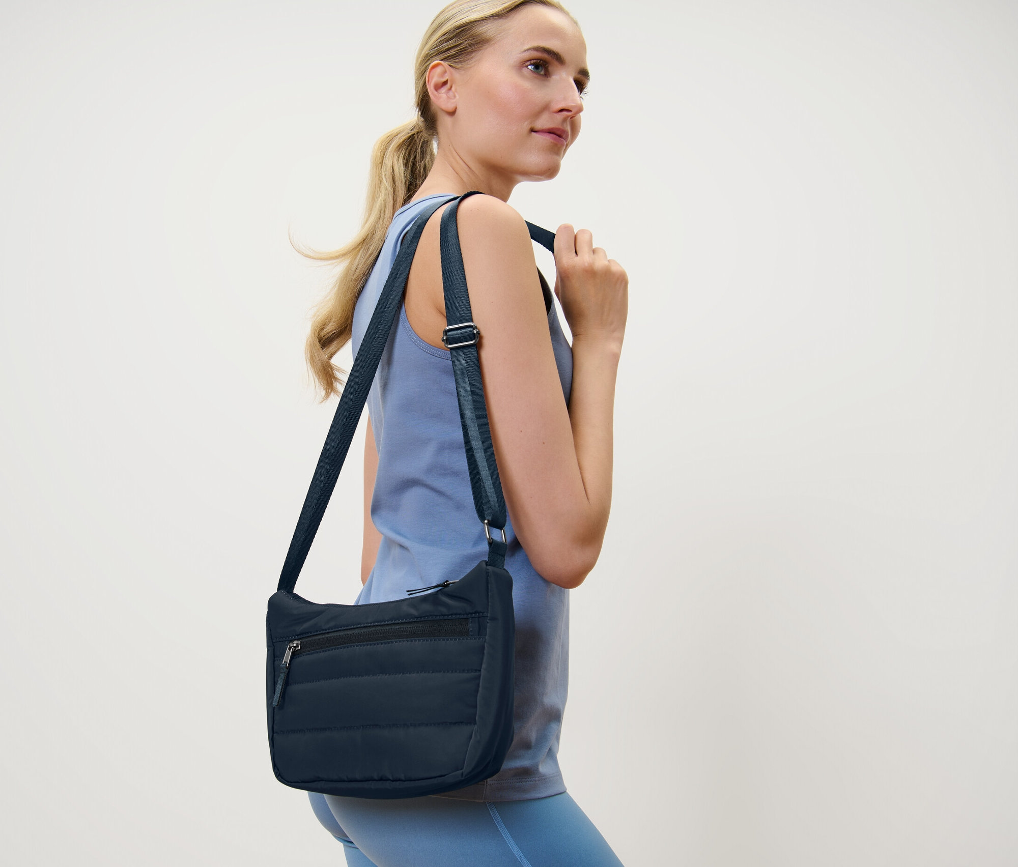 Blonde Frau mit Umhängetasche.