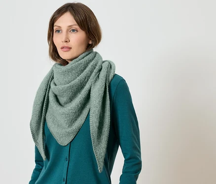 Frau trägt einen grünen Schal und einen grünen Pullover.
