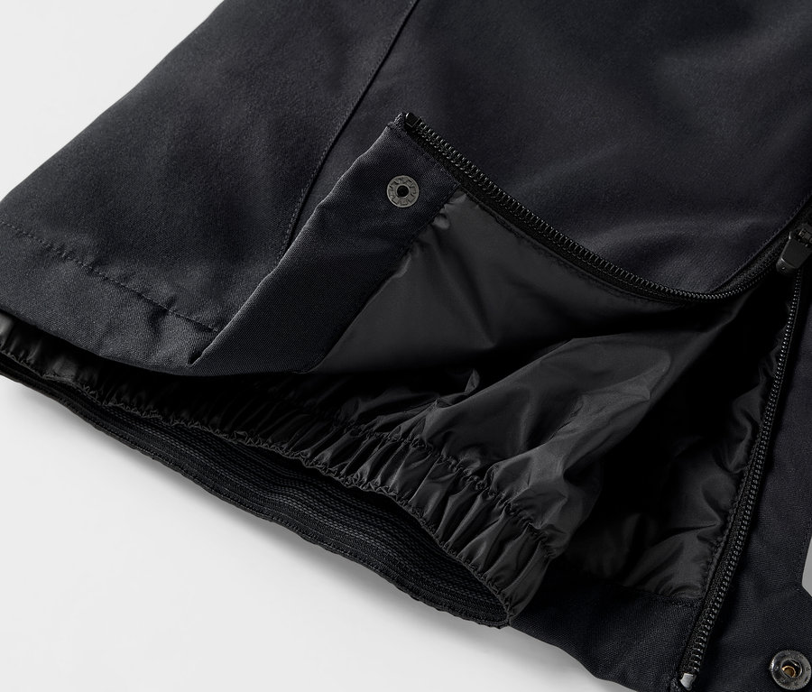 Detail einer schwarzen Hose mit geöffnetem Reißverschluss und Druckknopf.