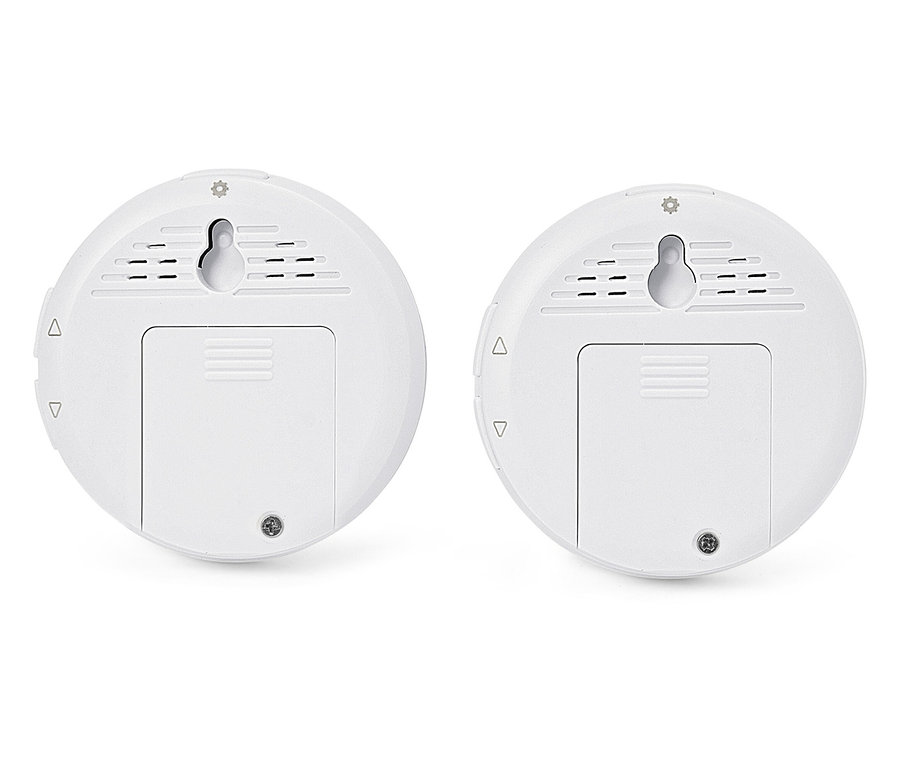 Zwei weiße, runde Sensoren mit Wandhalterungen und Batteriefachabdeckungen.