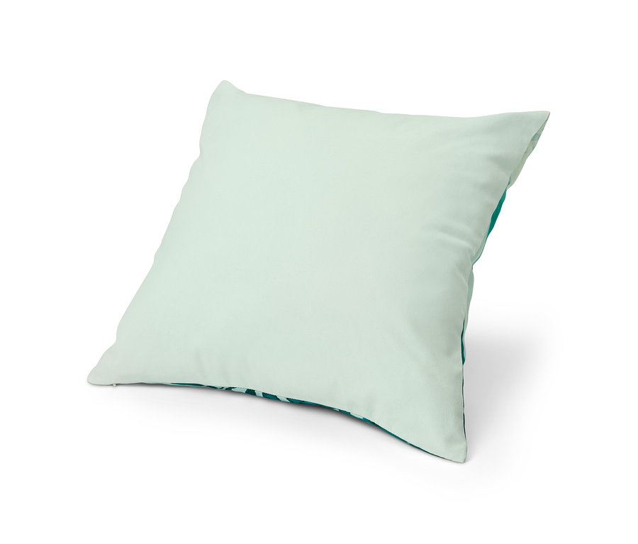Ein hellgrüner Dekokissen-Bezug liegt auf einem weißen Hintergrund.