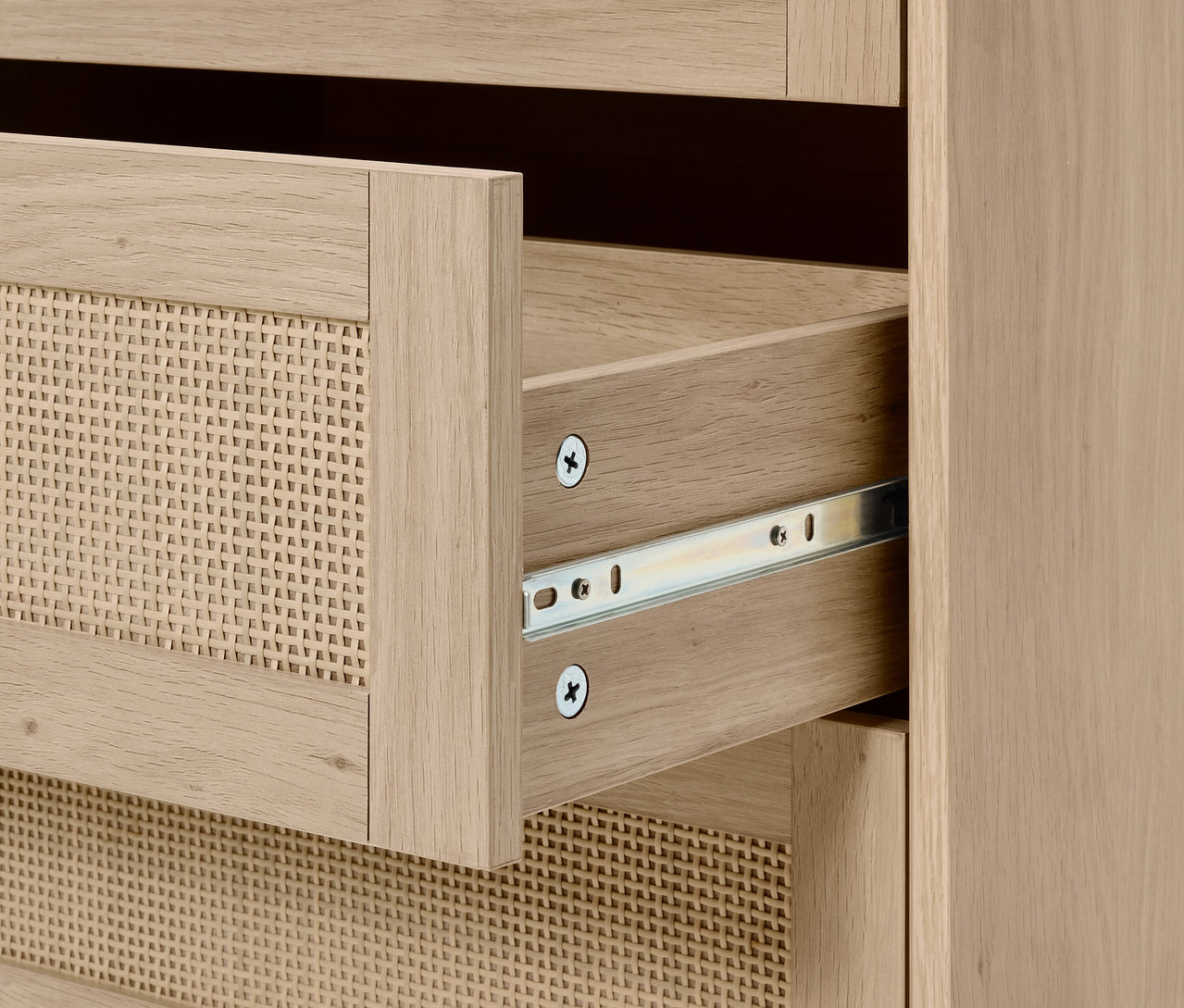 Detail einer Kommode mit offener Korbschublade.