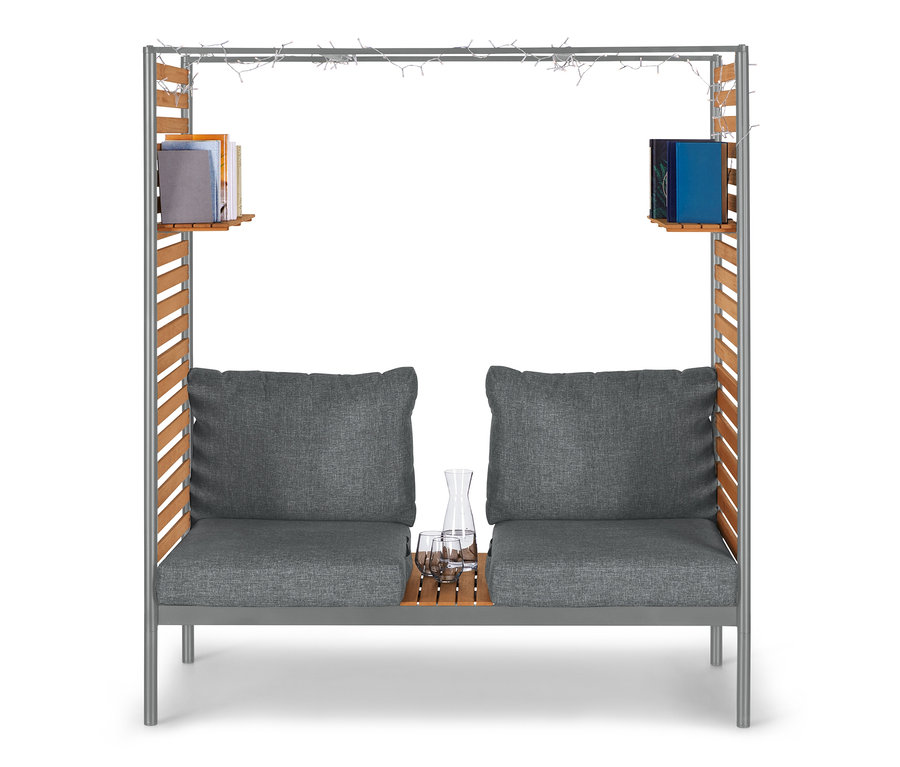 Graue ScanCom Outdoor-Lounge mit Fußhocker, Buechern und Getraenken.