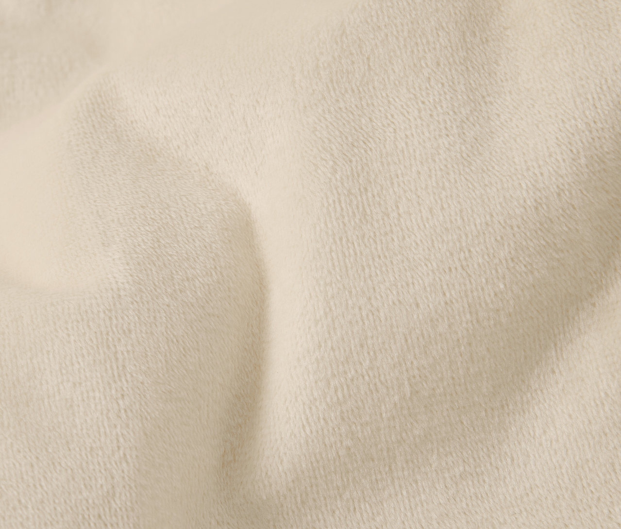 Detailaufnahme eines cremefarbenen Stoffes mit feiner Textur und Falten.
