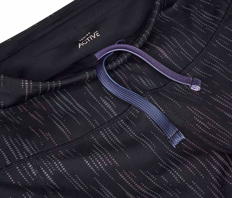 Detailaufnahme einer schwarz-grauen Sportleggings mit lila Kordelzug in der Taille.