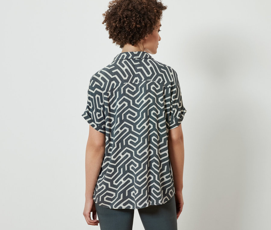 Frau von hinten trägt eine bedruckte Bluse.