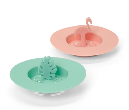 Zwei Abflusssiebe aus Silikon: eins in Pfirsichfarbe mit Flamingo, eins in Grün mit Blatt.