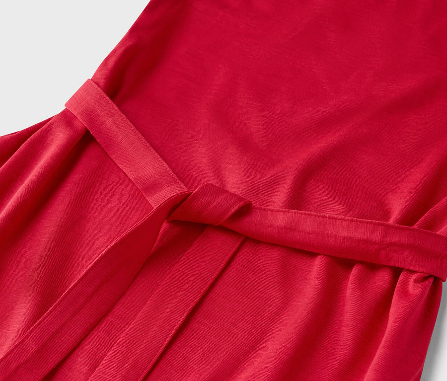 Nahaufnahme eines roten Kleides mit einem gebundenen Gürtel.