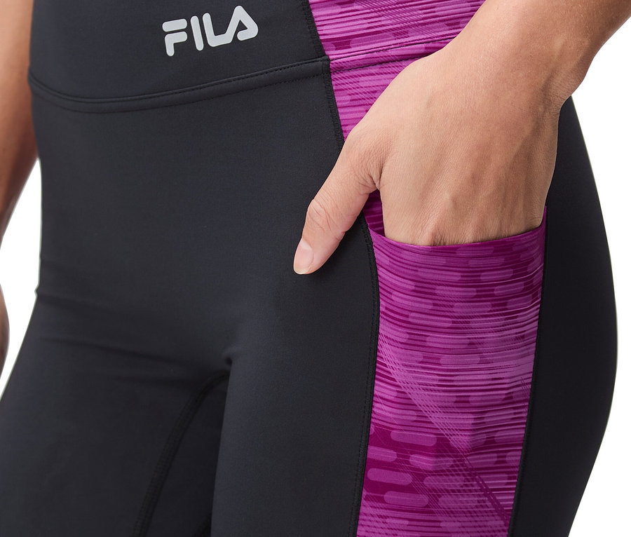 Frau trägt schwarze Leggings mit pinkfarbenem Muster und Fila-Logo.