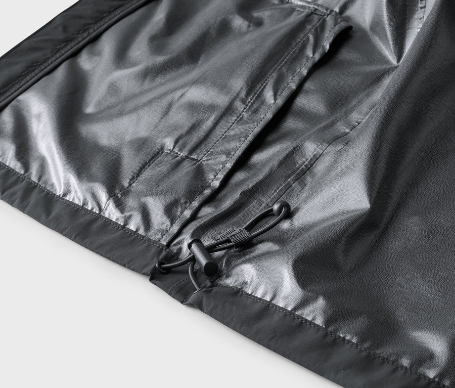 Nahaufnahme der Innenseite einer grauen Jacke mit Tasche und Kordelzug.