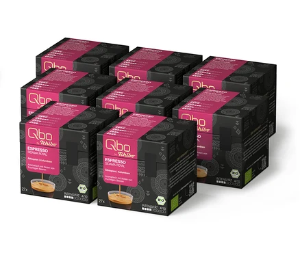 Sechs schwarze und pinke Qbo Espresso SIDAMA ROYAL Kapselpackungen, in zwei Reihen angeordnet, mit Kaffeebild, Herkunft und Bio-Siegel.