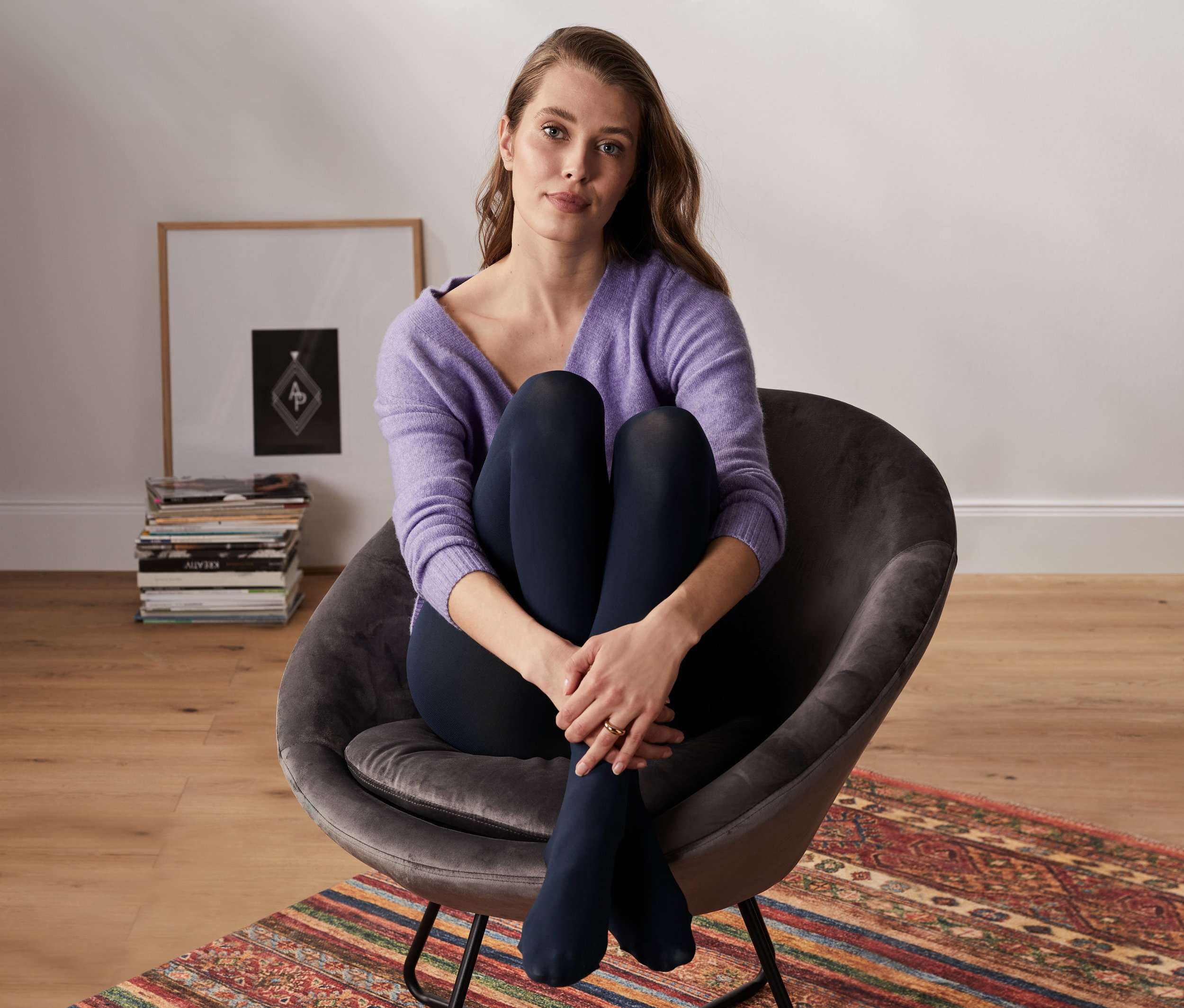 Frau sitzt im Sessel und trägt eine blickdichte Strumpfhose, 2er-Pack.