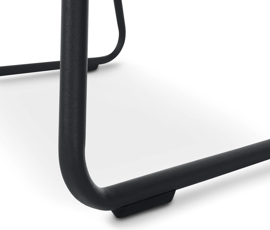 Detailansicht eines beige gepolsterten Schalenstuhls mit Metallbeinen.