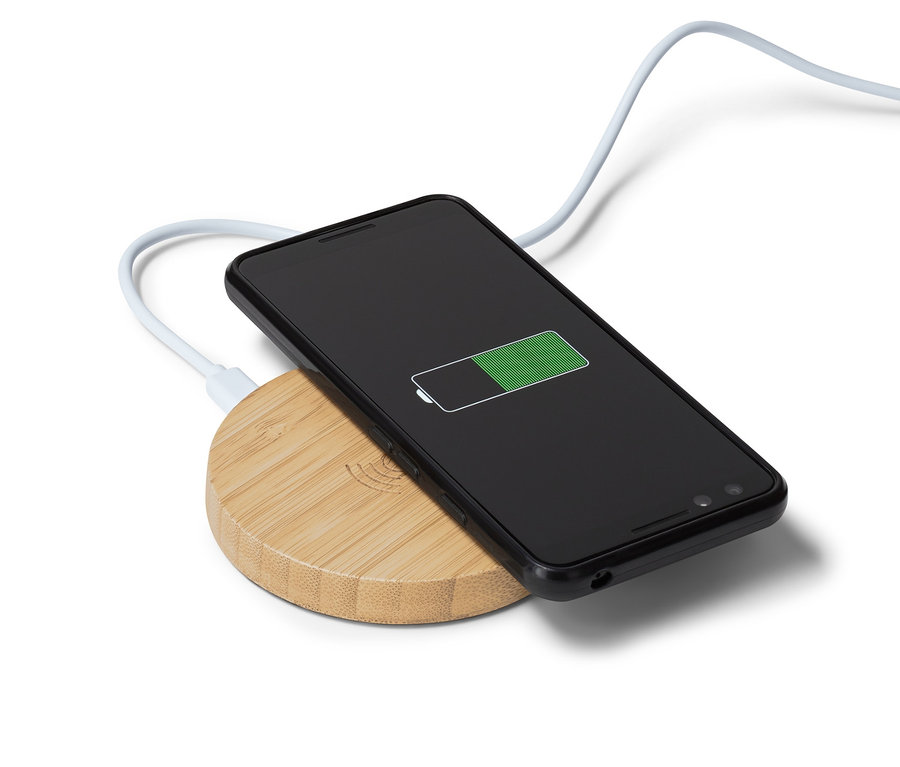 Schwarzes Smartphone wird auf einer kabellosen Qi-Ladestation aus Bambus aufgeladen.
