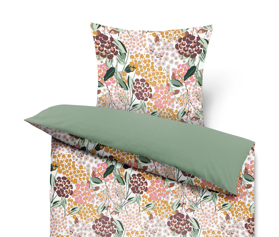 Bettwäsche mit Blumenmuster und grünem Kissen.
