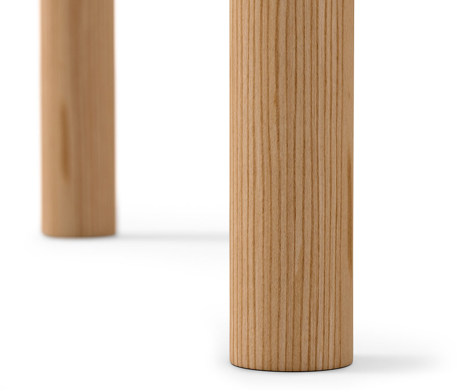 Detailansicht von zwei Beinen eines runden Beistelltisches aus hellem Holz auf weißem Hintergrund.