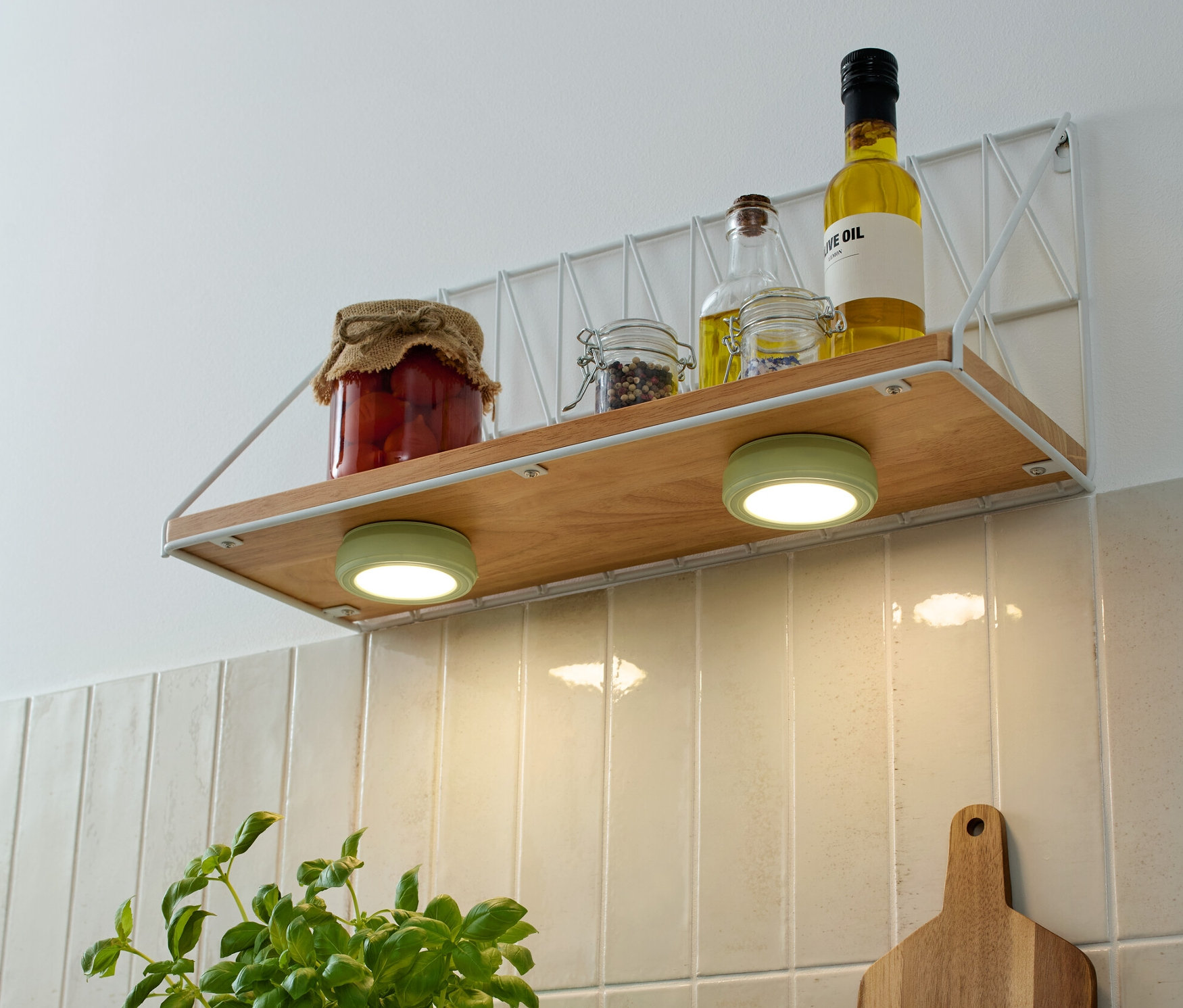 Auf einem Regal befinden sich zwei LED-Multifunktionsleuchten, Gläser und Öle.