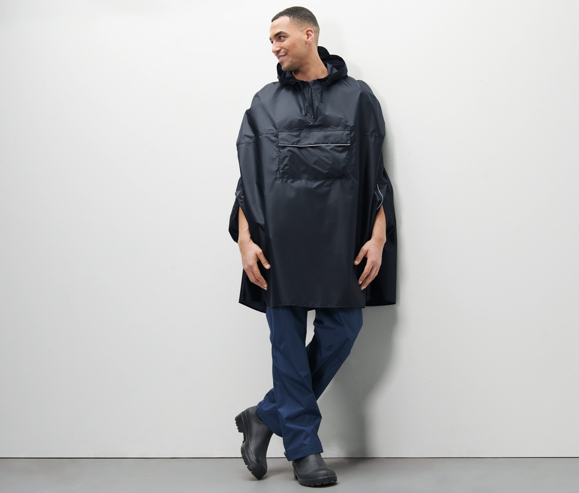 Mann posiert in blauem Unisex-Regenponcho.