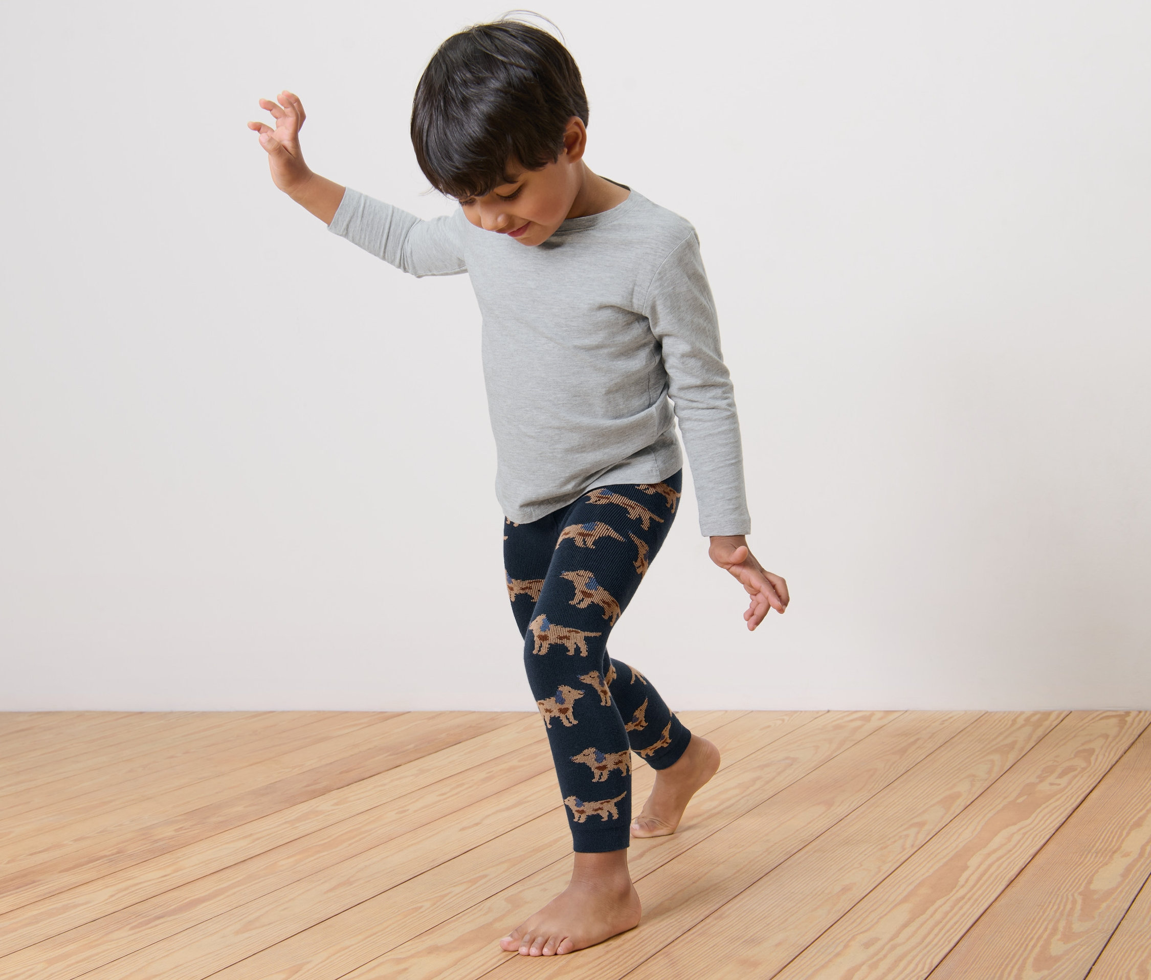 Ein Junge tanzt in einer Thermoleggings mit Dackel-Muster.