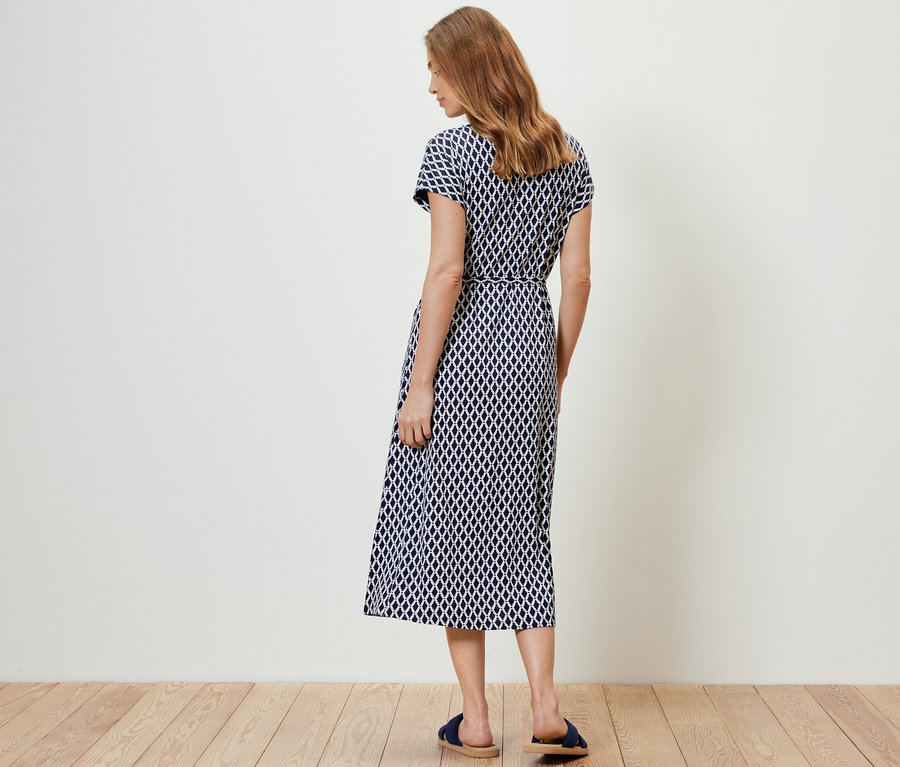 Frau von hinten in einem bedruckten Jerseykleid.