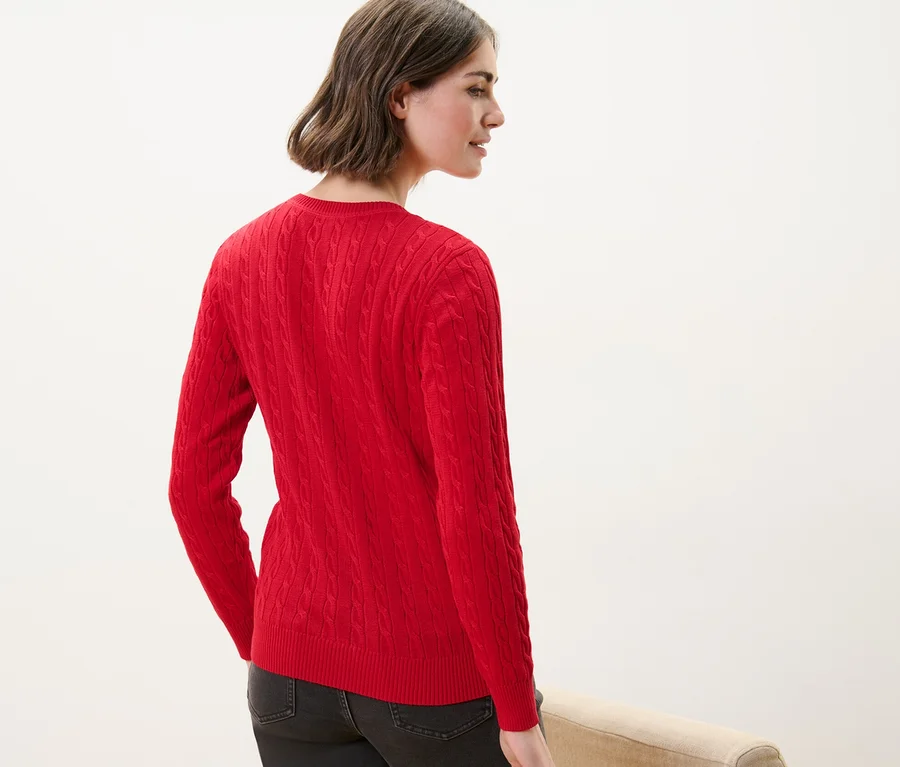 Frau von hinten trägt einen roten Zopfstrickpullover.