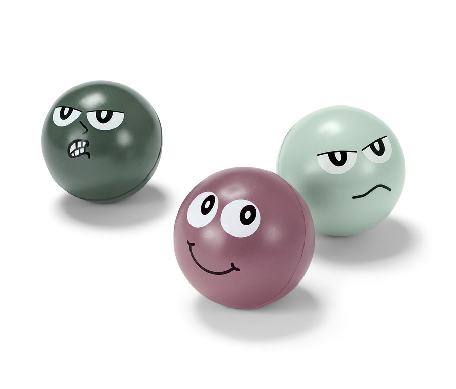 Drei Anti-Stressbälle mit Gesichtern. Einer ist grün mit wütendem Gesichtsausdruck, einer ist lila mit lächelndem Gesichtsausdruck und einer ist hellgrün mit verärgertem Gesichtsausdruck.