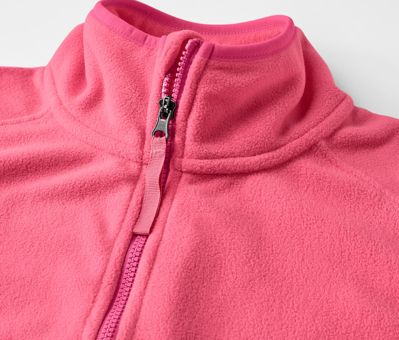 Detail einer pinken Fleece-Weste mit Reißverschluss.
