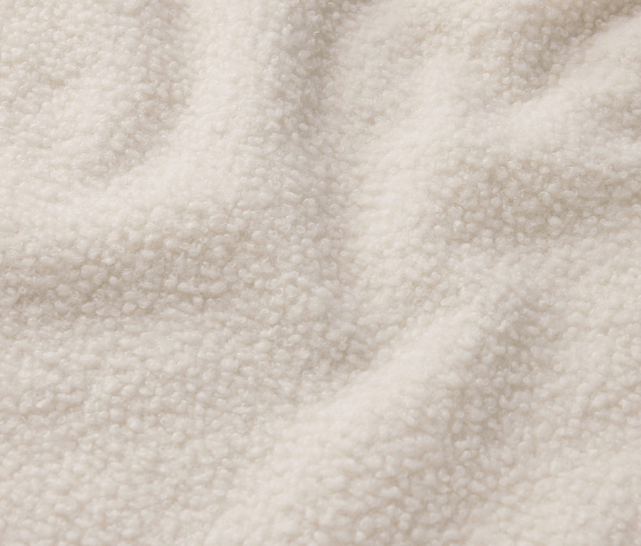 Detailaufnahme eines cremefarbenen Shearling-Stoffs.